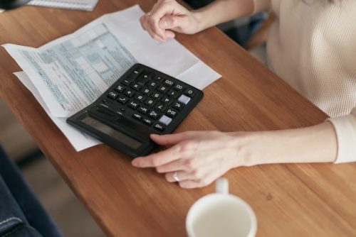 person at desk with papers and calculator