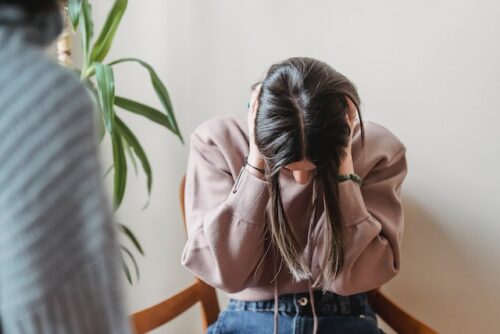 girl holding head in hands