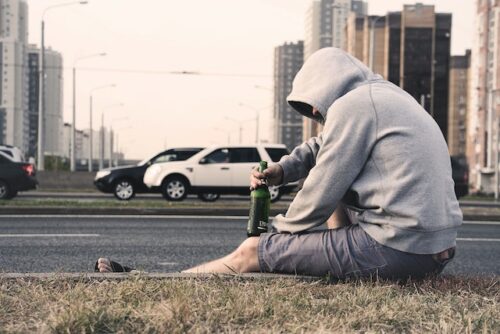 man on side of road with alcohol
