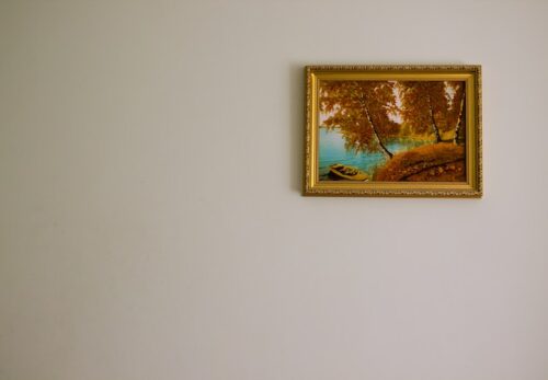 artwork in gold frame hung on wall