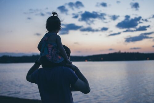 dad standing with child on shoulders