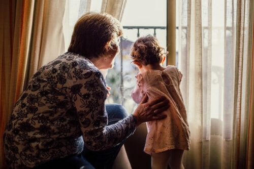 grandmother and granddaughter in front of window