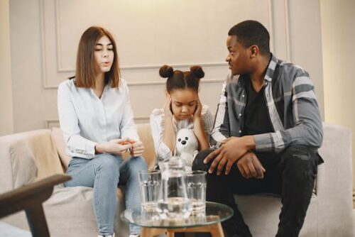 family sitting on couch child covering ears