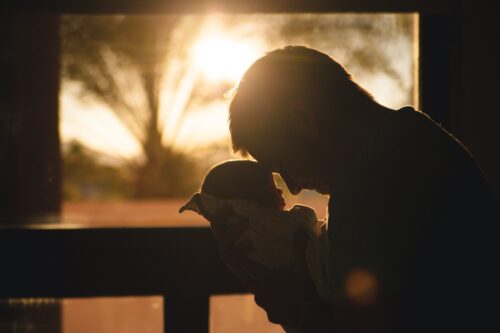 father holding baby silhouette
