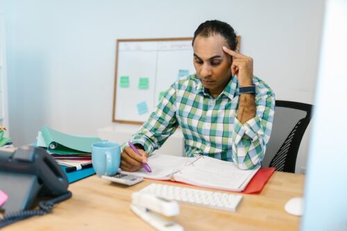 stressed man doing math at table
