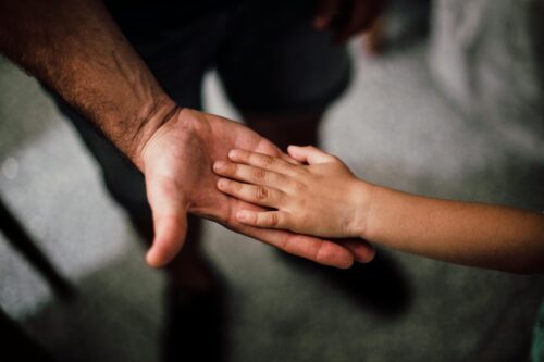 child holding hand of parent