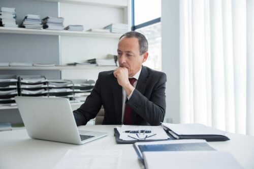 man looking at papers in office