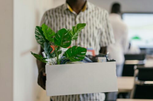 man holding box of belongings from job